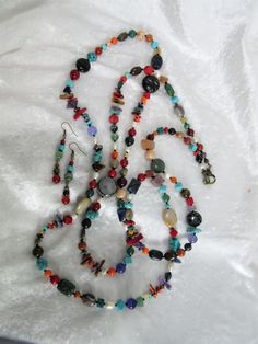 This multi gemstones necklace set is made so that each one is unique. Because all the beads vary in color, shape and size, and it is a random design, each necklace will be slightly different from the picture. I have tried to duplicate the earrings as closely as possible. This is a multi-colored celebration of gemstones from around the world. The necklace is 65 inches long and the earrings dangle 1 and 3/4 inches. I love collecting different shapes and sizes of gemstone beads and blending the col Artisan Multicolor Jewelry With Polished Beads, Bohemian Multicolor Gemstones For Gift, Multicolor Beaded Necklaces With Natural Stones, Unique Multicolor Jewelry With Natural Stones, Bohemian Mixed Color Jewelry For Gift, Handmade Adjustable Multicolor Gemstones, Multicolor Dangle Beaded Necklaces With Gemstone Beads, Artisan Multicolor Jewelry For Healing, Colorful Bohemian Gemstone Jewelry