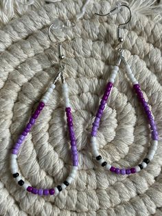 Purple, lavender ,  white and fusia colored beaded teardrop loop dangle earrings.  Made with multicolored glass seed beads attached to a hypoallergenic earring ring fixing. White Drop Hoop Earrings, Hypoallergenic Adjustable White Beaded Earrings, Lavender Beaded Drop Earrings, Lavender Drop Beaded Earrings, White Beaded Teardrop Earrings, White Dangle Hoop Earrings With Colorful Beads, White Dangling Hoop Earrings With Colorful Beads, Lavender Beaded Dangle Earrings, Purple Beaded Dangle Earrings With Tiny Beads