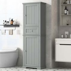 a white toilet sitting next to a tall gray cabinet