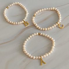 Adorn your wrist with a stylish Freshwater Pearl Initial Charm Bracelet. Featuring freshwater pearls and a clean font initial charm, this bracelet provides both timeless elegance and personalization. It makes the perfect gift for yourself or your loved ones and is suitable for everyday wear or special occasions. Stack it with other bracelets for a stunning layered look. Dimensions: approximately 6.5" before stretch Genuine freshwater pearls 18k gold plated stainless steel initial charm with wate Clean Font, Initial Charm Bracelet, Hair Setting, Pearl Collection, Moissanite Jewelry, Initial Charm, Scrunchie Hairstyles, Bead Strand, Steel Jewelry