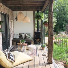 an outdoor patio with furniture and potted plants on the porch area, surrounded by greenery