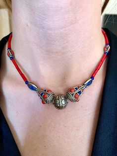 This necklace features hand made beads from Tibet as well as coral and lapis lazuli beads.  Coral is believed to prevent ill fortune and bring prosperity and luck.  Lapis lazuli embodies inner truth. It promotes self awareness and stimulates the desire for knowledge, truth, and understanding. Artisan Silver Beads Necklace For Healing, Handmade Good Luck Necklace With Round Beads, Handmade Good Luck Necklaces With Round Beads, Spiritual Red Coral Beaded Necklaces, Spiritual Red Coral Necklaces With Large Beads, Handmade Lapis Lazuli Beaded Necklace For Spiritual Style, Traditional Jewelry With Round Lapis Lazuli Beads, Colorful Lapis Lazuli Beaded Necklaces As Gifts, Spiritual Red Necklaces With Silver Beads