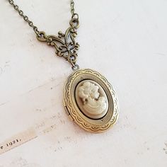 Dainty and detailed Victorian lady cameo in a slightly pearly golden brown on an engraved antiqued bronze plated locket, Inside there is space for two photographs, or a little secret treasure. It is suspended under a pretty decorative connector on an antique bronze plated chain with a lobster clasp. The locket is 1 1/4 inches (30 mm) from top to bottom, and opens to reveal a space for photos, or perhaps a secret message. The antique bronze plated chain has a lobster clasp, and an extension chain Luxury Antique Oval Locket Necklace, Locket Necklace Vintage, Mood Stone, Oval Locket, Star Chain, Victorian Lady, Photo Locket, Cameo Pendant, Vintage Victorian