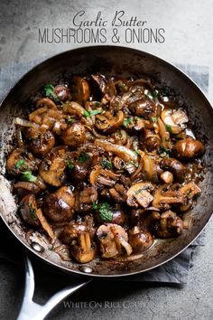 mushrooms and onions cooking in a skillet with a spoon on the side that says garlic butter mushrooms & onions