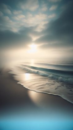 the sun is setting over the ocean with waves coming in from the shore and sand on the beach