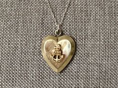 This vintage sweetheart necklace bears a US Navy insignia on a heart-shaped locket. The locket is hallmarked 10K gold-filled sterling from D'Aguanno Bros. The chain is a new, 14K gold-filled, and measures 18 inches. This piece has been restored as close as possible to its original condition, cleaned gently by hand with steam, polishing cloths, and good old-fashioned elbow grease.This vintage item has been loved and cherished by a previous owner, there will be some slight wear or imperfections. I Classic Heart Jewelry For Collectibles, Heart Pendant Necklace With Vintage Charm For Anniversary, Anniversary Heart Pendant Necklace With Vintage Charm, Vintage Charm Heart Pendant Necklace For Anniversary, Vintage Charm Heart Pendant Jewelry For Anniversary, Vintage Heart Pendant Necklace For Anniversary, Anniversary Necklace With Vintage Charm And Heart Pendant, Vintage 14k Gold Charm Necklace For Gift, Heirloom Necklace For Valentine's Day