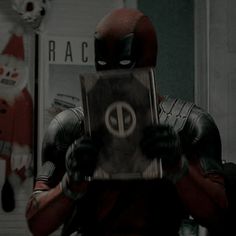 a deadpool character holding a box with the word deadpool on it