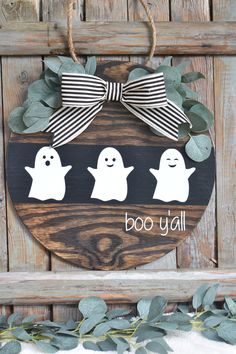 a wooden sign that says boo y'all with ghost faces