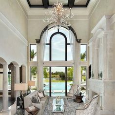 a large living room with two couches and a chandelier hanging from the ceiling