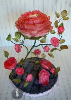 a pink rose sitting on top of a wooden table