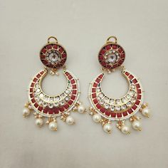 Adorn yourself with these Coral & Kundan Chandbali Earrings, crafted in gold foil. Featuring coral accents paired with Kundan work, these chandbalis blend traditional craftsmanship with timeless elegance. Perfect for special occasions, they add a regal touch to any ensemble. Length: 3" to 3.5" Material: 24Kt gold foil, lac Stones: Kundans, semi precious corals, semi precious pearls Traditional Gold Chandelier Earrings With Cutdana, Gold Chandbalis For Navratri, White Chandbali Fusion Earrings, Gold Meenakari Chandbalis For Celebration, Traditional Gold Chandbalis For Navratri, Gold Fusion Hoop Earrings For Festive Season, Gold Fusion Hoop Earrings For Festive Occasions, Festive Fusion Style Gold Hoop Earrings, Traditional Bridal Earrings With Cutdana For Gifts