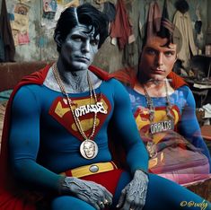 two young men dressed as superman and the man in red is sitting on a couch