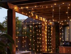 an outdoor covered patio with string lights hanging from the ceiling