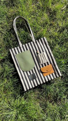 a bag laying on top of a grass covered field next to a pair of scissors