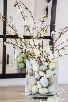 a vase filled with eggs and flowers on top of a table