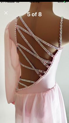 the back of a woman's pink dress with beading and straps on it