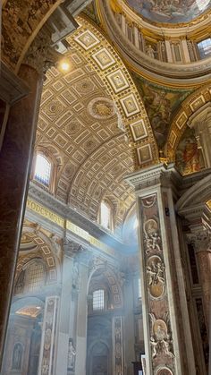 the inside of an ornate building with gold and white paint on it's walls