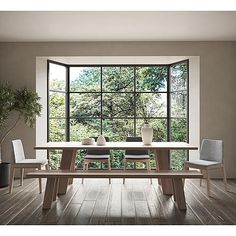 a dining room table and chairs in front of a large window with the view of trees outside