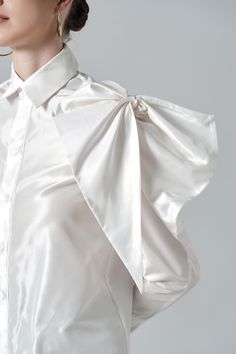 With a large size bowtie detail at the shoulder, the classic shirt now stands out like never before. High-quality silk material is selected to bring a moderate shine to the surface and created an impressive visual effect for the product. Note:*Processing time takes 7-10 working days (including 3-5 working days for manufacturing and NOT including shipping time)**Backorder Definition- The product is low in stock and in case the customer purchased successfully after out of stock, the order will nee Elegant Party Top With Bow, Luxury Satin Formal Shirt, Elegant Silk Tops With Bow Detail, Elegant Silk Tops With Bow, Elegant Party Tops With Pleated Sleeves, Elegant Silk Shirt For Daywear, Elegant Spring Tops With Satin Bow, Elegant Summer Blouse With Bow, Elegant Tops With Satin Bow For Spring