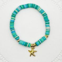 Embrace the essence of the ocean with this Tropical Starfish Bracelet. This stunning piece is crafted with vibrant turquoise and aqua beads, accented with a gold starfish charm that captures the spirit of the sea. Perfect for beach lovers, summer outfits, or anyone looking to add a touch of tropical charm to their jewelry collection. Details: *Materials: High-quality turquoise and aqua vinyl disc beads, gold starfish charm, and gold accent beads. *Length: 7 inches on elastic cord allowing stretc Turquoise Beachy Bracelet Jewelry, Beachy Turquoise Bracelet Jewelry, Vacation Starfish Bracelets With Colorful Beads, Beachy Turquoise Round Bead Bracelets, Beachy Turquoise Round Beaded Jewelry, Colorful Beads Starfish Bracelet For Vacation, Turquoise Beaded Bracelets For Beach With Ocean Style, Turquoise Beaded Starfish Bracelets For Summer, Turquoise Jewelry With Starfish Charm For Vacation