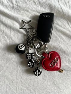 a cell phone and keychain laying on top of a bed