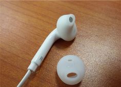 a pair of ear buds sitting on top of a wooden table