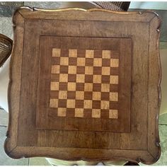 a wooden chess board sitting on top of a table next to a wicker basket