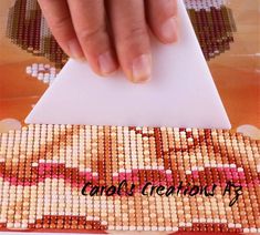 a person is making a cross stitch pattern on a piece of paper