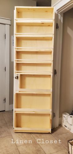 an unfinished bookcase in the corner of a room with white walls and tile flooring