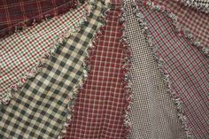 many different plaid fabrics are stacked together