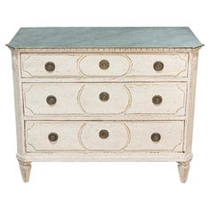 an old white dresser with blue marble top