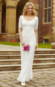 a woman in a white dress is standing on some steps and smiling at the camera