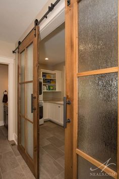 an open glass door leading to a kitchen