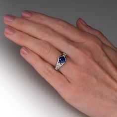 This delightful ring is centered with one (1) round mixed cut natural sapphire set into a half-bezel setting. The top face of the shank is accented with four (4), channel set, round brilliant cut diamonds. The ring measures 9.4mm at the top, rises 7.1mm above the finger, tapering to 3.4mm wide and 1.6mm thick at the base of the shank. This ring is currently a size 6.5. The sapphire shows light abrasions. Luxury Sapphire Ring With Round Stone, Timeless Sapphire Ring With Bezel Setting, Lab-created Sapphire Ring With Accent Stones In Round Cut, Elegant Sapphire Ring With Bezel Setting, Round Sapphire Ring With Bezel Setting, Elegant Round Sapphire Ring With Bezel Setting, Lab-created Sapphire Ring With Accent Stones And Round Cut, Elegant White Gold Sapphire Ring With Bezel Setting, Round Channel Set Lab-created Sapphire Jewelry