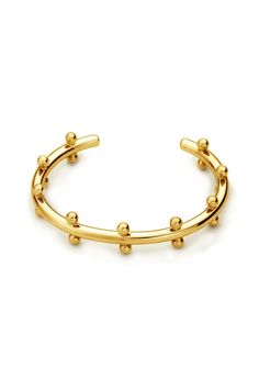 a gold cuff bracelet with balls on the side and two rows of beads at the end