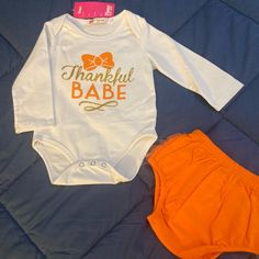 This Long Sleeve Onesie Set Is Perfect For Your Baby's First Thanksgiving. The Onesie Says Thankful Babe On Front In Orange And Gold And Comes With A Pair Of Orange Bloomers That Are Ruffled On The Back With A Matching Gold Bow. So Cute! Babys First Thanksgiving, Thanksgiving Onesie, First Thanksgiving, Orange And Gold, Month Colors, Long Sleeve Onesie, Orange White, Matching Sets, Shirt Shop