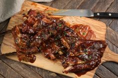 some meat on a wooden cutting board with a knife