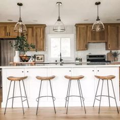 three stools sit at the center of a kitchen island