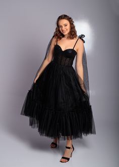 Step into elegance with this stunning black corset midi tulle dress, perfect for proms, parties, weddings, and formal events. This exquisite evening dress features a fitted corset bodice adorned with shimmering sequins, creating a glamorous and sophisticated look. The flowing tulle skirt adds a touch of whimsy and movement, making you feel like a true princess. The midi length offers a modern twist on classic elegance, while the delicate straps and bow detailing add a playful touch. Crafted from Fitted Tulle Evening Dress Tea Length, Black Corset Dress With Sheer Fitted Bodice, Black Corset Dress For Prom Evening, Black Corset Dress With Sheer Bodice, Organza Corset Dress For Debutante Ball And Prom, Organza Corset Dress For Prom Season And Debutante Ball, Organza Corset Dress For Debutante Ball During Prom Season, Black Corset Dress With Sweetheart Neckline For Evening, Glamorous Tulle Corset Dress With Fitted Bodice