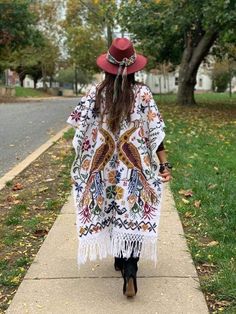 This Beautiful Hand Embroidered Poncho is perfect for keeping you warm and stylish at the same time. It has gorgeous hand embroidered details in both the front and back of the poncho. This poncho is handmade by Mexican Artisans and is completely one of a kind. Unisex Note: This poncho has open sides and comes in one size which is ideal for sizes, Small, Medium, Large, Extra Large, 2x, 3x. Bohemian Long Sleeve Embroidered Poncho, Embroidered Long Sleeve Poncho For Festival, Folk Style Embroidered Festival Kimono, White Casual Kimono For Winter, Bohemian Embroidered Kimono With Kimono Sleeves, Bohemian Embroidered Kaftan For Fall, Bohemian Kimono With Intricate Embroidery, Winter Multicolor Embroidered Kimono, Embroidered Multicolor Winter Kimono