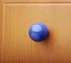 a blue door knob on a wooden surface