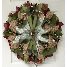 a wreath hanging on the front door of a house with scissors and ribbon attached to it