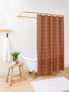 a white bath tub sitting next to a wooden stool in front of a shower curtain