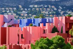 colorful buildings with trees and mountains in the background