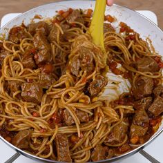 someone is stirring spaghetti with meat and sauce