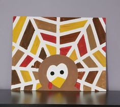 a painting of a turkey on top of a wooden table next to a gray wall