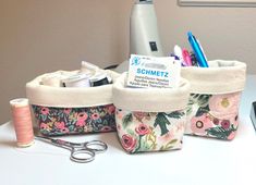 three storage bags with sewing supplies in them on a table next to a hairdryer and scissors