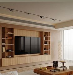 an empty living room with a large tv mounted on the wall and bookshelves