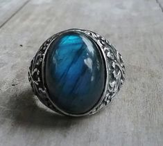 solid large labradorite ring mans wedding or dress ring beautiful scroll antique effect. solid sterling silver (925) Solid not hollowed out in the back stone flashes blues and grey with black flecks..few inclusions. Avaliable in many stones Stone measures 17 mm x13mm (6/8 ''x 4/8'' approx.) The stone will be set once sold.1 This ring I can make any size. It weights 12.2 gms approx It is 21mm (7/8 '' wide) It tapers to 3.5mmat the back If a different size is required pls convo me Gemstone Rings Vintage, Turquoise Men, Barrel Rings, Chunky Ring, Chunky Rings, Ring Antique, Labradorite Ring, Large Ring, Dress Rings