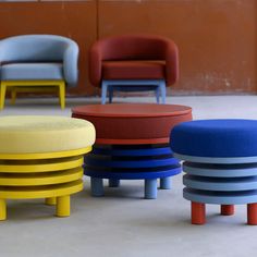 several different colored stools and chairs in a room